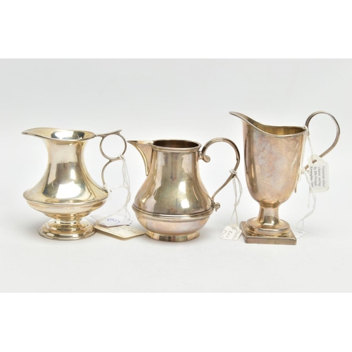 183 - THREE SILVER MILK JUGS, each in a different form fitted with scrolling handles, each with a full sil... 