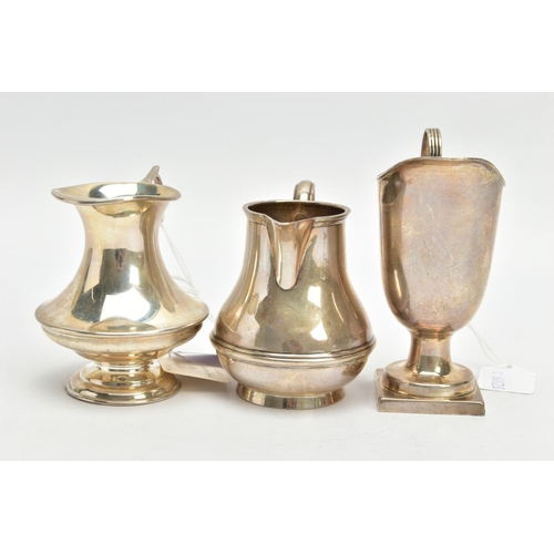 183 - THREE SILVER MILK JUGS, each in a different form fitted with scrolling handles, each with a full sil... 