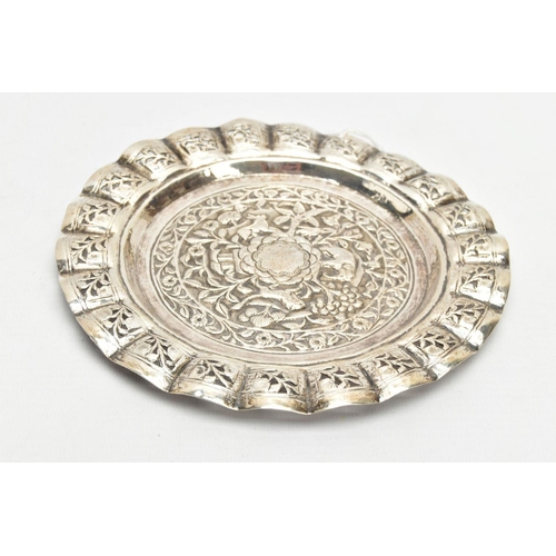 188 - AN INDIAN WHITE METAL TRAY, of a circular form, decorated to the centre with an embossed forest scen... 