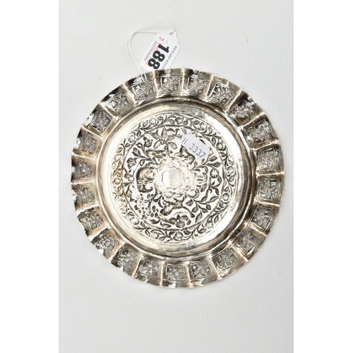 188 - AN INDIAN WHITE METAL TRAY, of a circular form, decorated to the centre with an embossed forest scen... 