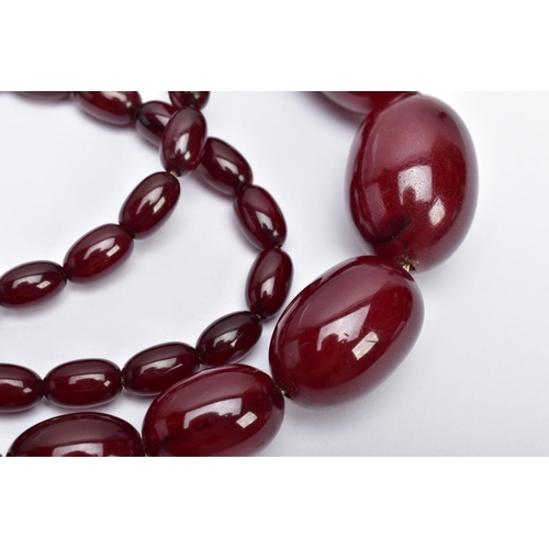 29 - A CHERRY AMBER BAKELITE NECKLACE,  graduating oval beads, largest measuring approximately 11mm x 7mm... 