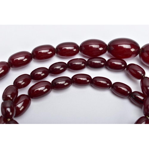 29 - A CHERRY AMBER BAKELITE NECKLACE,  graduating oval beads, largest measuring approximately 11mm x 7mm... 