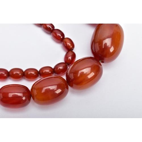 30 - A BAKELITE BEADED NECKLACE,  graduating oval beads, orange/brown in colour, fitted with a bead style... 