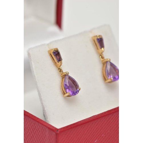 42 - A PAIR OF YELLOW METAL AMETHYST DROP EARRINGS, each designed with a claw set, pear cut amethyst drop... 