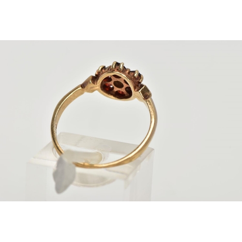 50 - A 9CT GOLD GARNET AND PEARL CLUSTER RING, centring on a seed pearl, within a surround of six circula... 