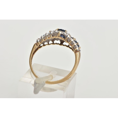 59 - A 9CT GOLD SAPPHIRE RING, designed with a central four claw set, oval cut blue sapphire, flanked wit... 