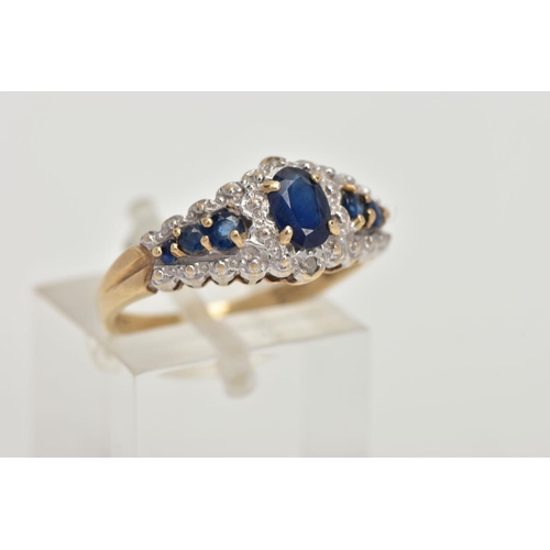 59 - A 9CT GOLD SAPPHIRE RING, designed with a central four claw set, oval cut blue sapphire, flanked wit... 