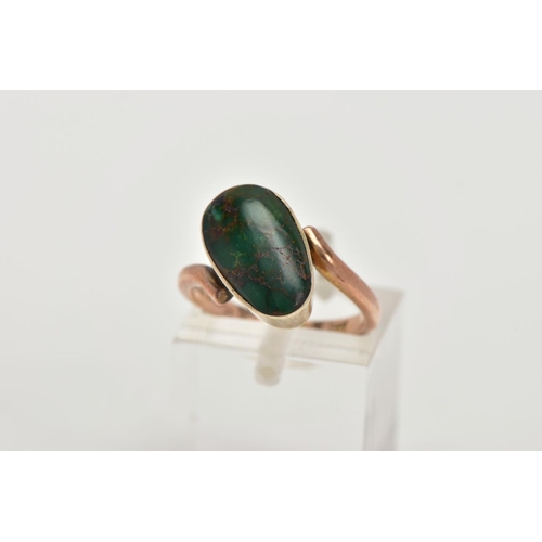 62 - A YELLOW METAL TURQUOISE RING, set with an oval green turquoise cabochon, collet mounted, within cro... 