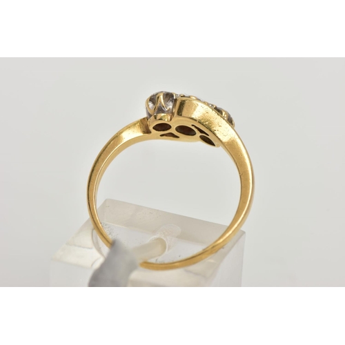 69 - AN 18CT GOLD THREE STONE DIAMOND RING, cross over design set with three round brilliant cut diamonds... 