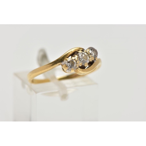 69 - AN 18CT GOLD THREE STONE DIAMOND RING, cross over design set with three round brilliant cut diamonds... 