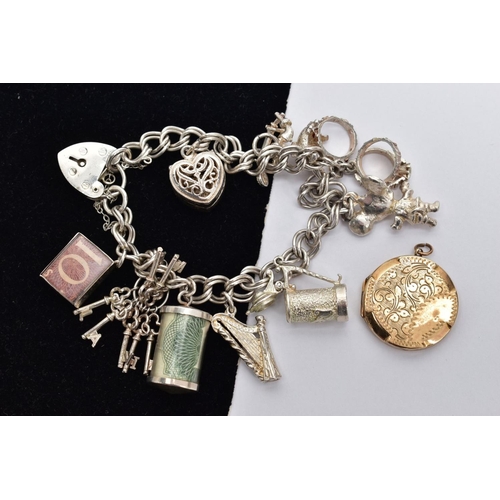 72 - A SILVER CHARM BRACELET AND A LOCKET, the double curb link bracelet, some links stamped with a sterl... 