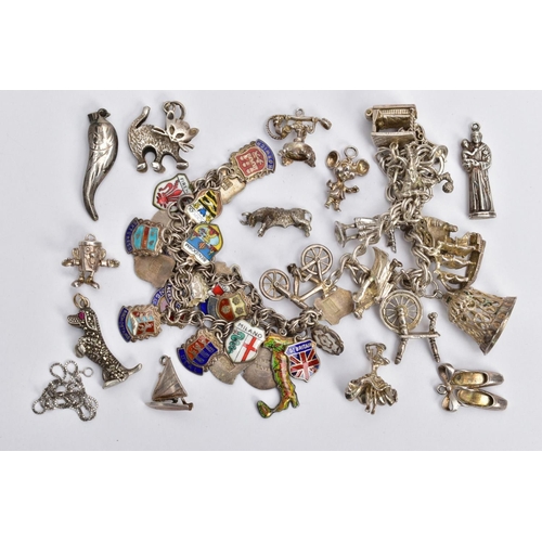 81 - TWO CHARM BRACELETS AND LOOSE CHARMS, the first a silver double curb link bracelet, fitted with nine... 