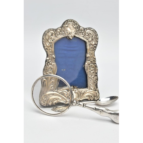 83 - A SILVER PHOTO FRAME, TEASPOON AND A MAGNIFYING GLASS, the photo frame of a wavy rectangular form, e... 