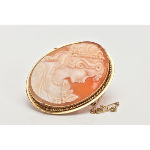 9 - A 9CT GOLD CAMEO BROOCH, an oval shell cameo depicting a lady in profile in a collet mount with a ro... 