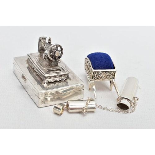 99 - THREE WHITE METAL ITEMS, to include a silver sewing needle box fitted with a sewing machine to the l... 