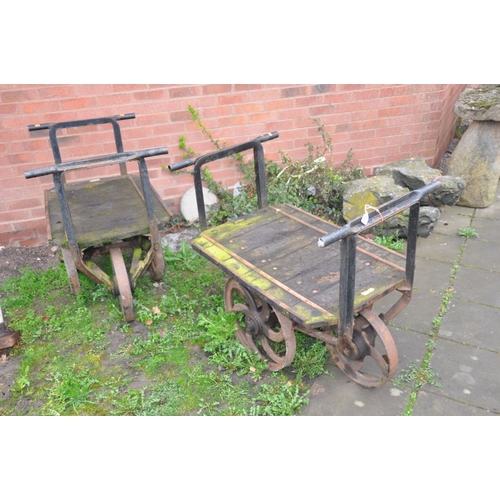 1223 - A PAIR OF CAST IRON OPEN PIT TROLLEYS with wooden iron banded beds, handles front and back with 4 ca... 