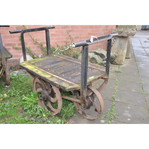 1223 - A PAIR OF CAST IRON OPEN PIT TROLLEYS with wooden iron banded beds, handles front and back with 4 ca... 