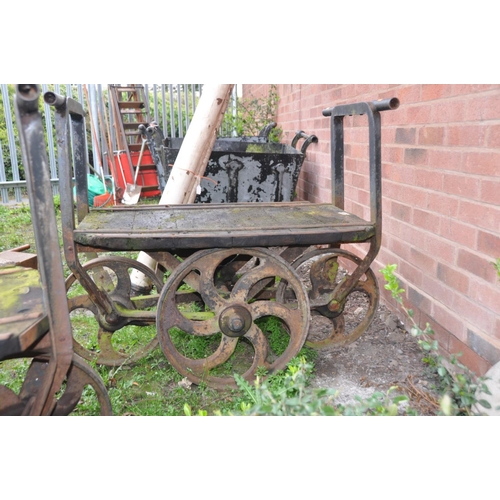 1223 - A PAIR OF CAST IRON OPEN PIT TROLLEYS with wooden iron banded beds, handles front and back with 4 ca... 