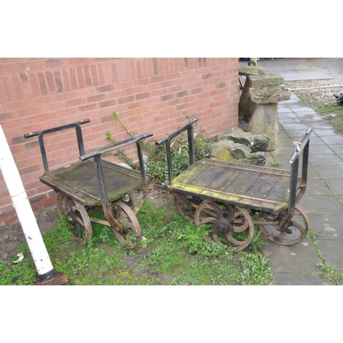 1223 - A PAIR OF CAST IRON OPEN PIT TROLLEYS with wooden iron banded beds, handles front and back with 4 ca... 