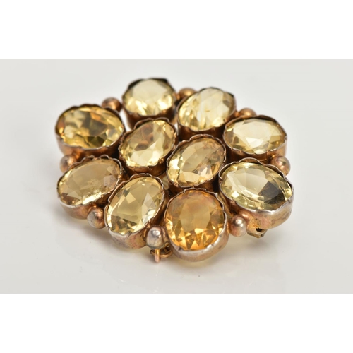 114 - A GILT CITRINE BROOCH, of an oval form set with ten oval cut citrines, each collet mounted with inte... 