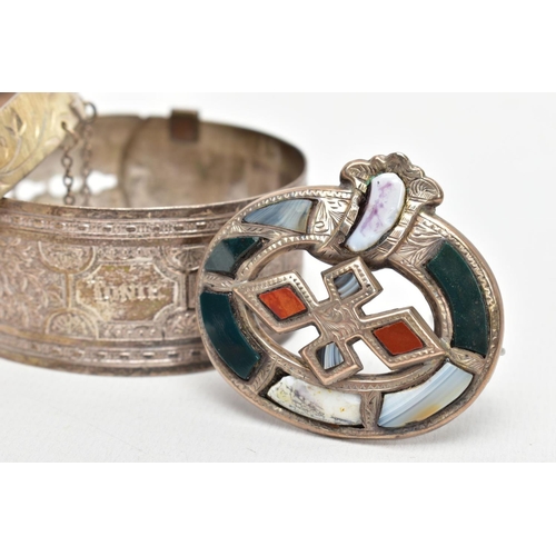 134 - TWO BANGLES AND A SCOTTISH BROOCH, the first a silver hinged bangle decorated with a diamond cut pat... 