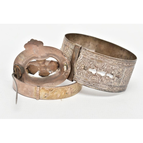 134 - TWO BANGLES AND A SCOTTISH BROOCH, the first a silver hinged bangle decorated with a diamond cut pat... 