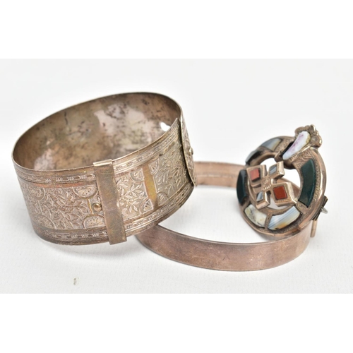 134 - TWO BANGLES AND A SCOTTISH BROOCH, the first a silver hinged bangle decorated with a diamond cut pat... 