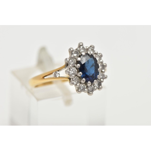 145 - AN 18CT GOLD SAPPHIRE CLUSTER RING, centring on an oval cut deep blue sapphire, claw set within a su... 