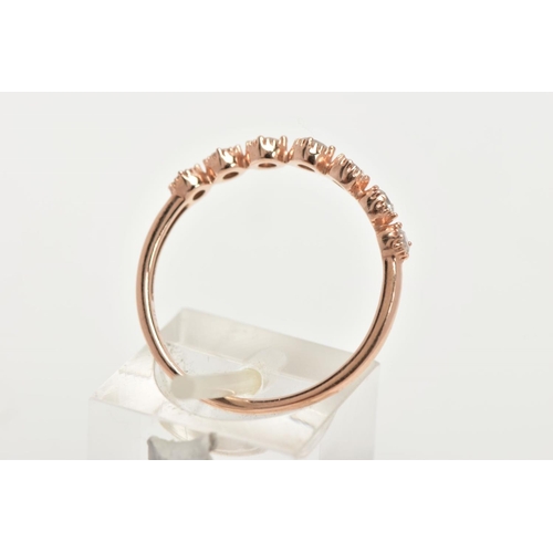 155 - A 9CT ROSE GOLD DIAMOND HALF ETERNITY RING, designed with a row seven round brilliant cut diamonds, ... 