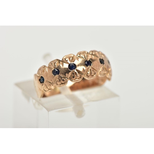 172 - A 9CT GOLD SAPPHIRE RING, a wide gold band ring with a floral engraved design, flush set with seven ... 