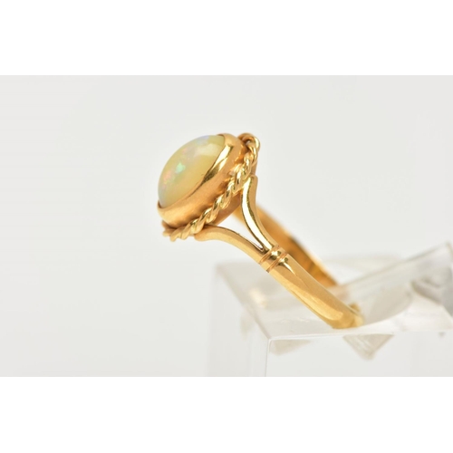 32 - AN 18CT GOLD OPAL RING, designed with an oval cut white opal cabochon, showing flashes of red, orang... 