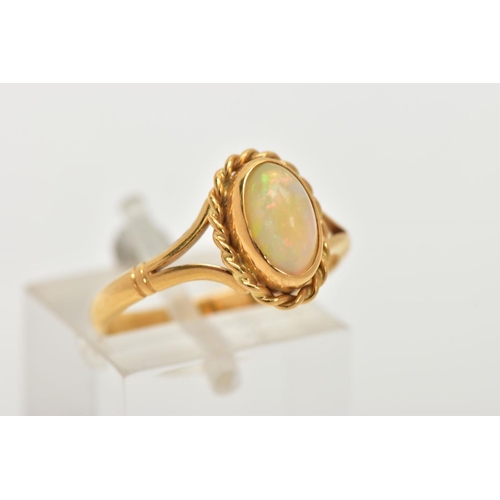 32 - AN 18CT GOLD OPAL RING, designed with an oval cut white opal cabochon, showing flashes of red, orang... 