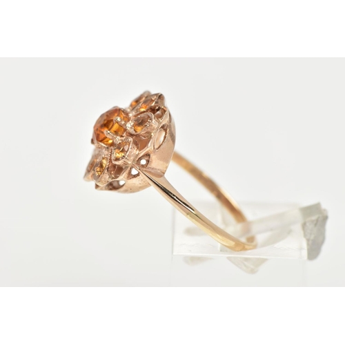 55 - A 9CT GOLD CLUSTER RING, in the form of a flower, set with a central circular cut orange stone asses... 