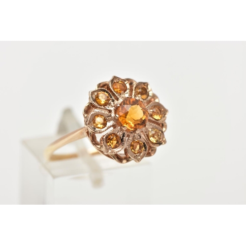 55 - A 9CT GOLD CLUSTER RING, in the form of a flower, set with a central circular cut orange stone asses... 