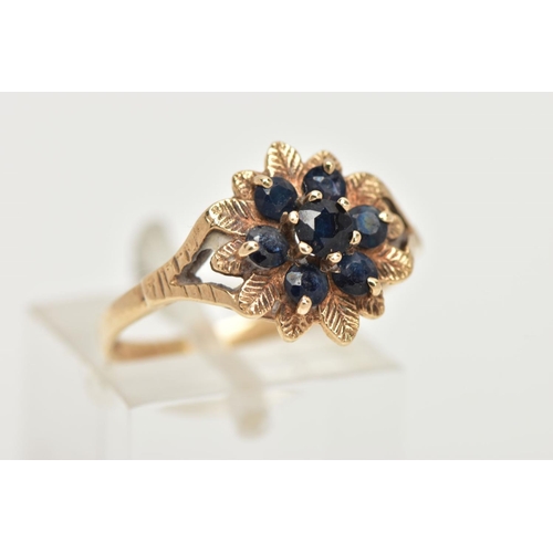 64 - A 9CT GOLD SAPPHIRE CLUSTER RING, of a flower form, set with seven circular cut deep blue sapphires,... 