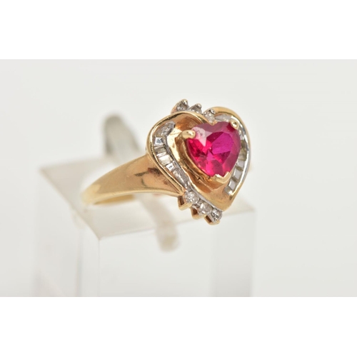 66 - A YELLOW METAL GEM SET RING, of a heart design set centrally with a synthetic heart cut ruby, in a s... 