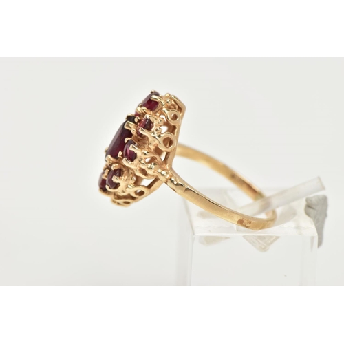 68 - A 14CT GOLD GARNET RING, of an oval form, set with a central marquise cut garnet within a surround o... 