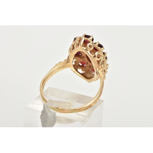 68 - A 14CT GOLD GARNET RING, of an oval form, set with a central marquise cut garnet within a surround o... 