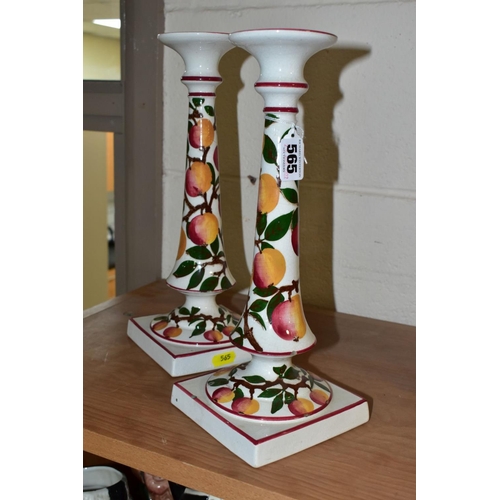 565 - A PAIR OF WEMYSS WARE CANDLESTICKS, painted with an apple design and red/pink rims, circular drip pa... 