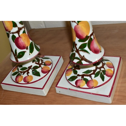 565 - A PAIR OF WEMYSS WARE CANDLESTICKS, painted with an apple design and red/pink rims, circular drip pa... 