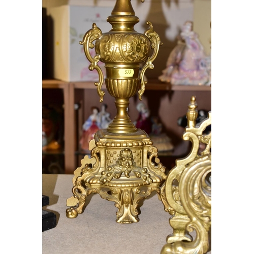 577 - A REPRODUCTION BRASS CLOCK GARNITURE, the clock with ornate cast brass case with twin handled urn su... 