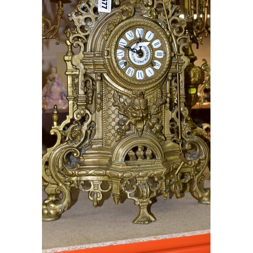 577 - A REPRODUCTION BRASS CLOCK GARNITURE, the clock with ornate cast brass case with twin handled urn su... 