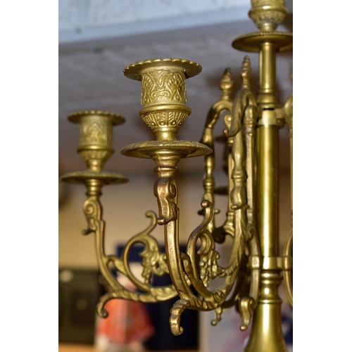 577 - A REPRODUCTION BRASS CLOCK GARNITURE, the clock with ornate cast brass case with twin handled urn su... 