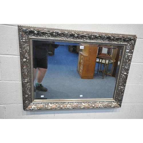 1518 - A LARGE RECTANGULAR SILVERED GILT WOOD BEVELLED EDGE WALL MIRROR, with carved foliate detail, length... 