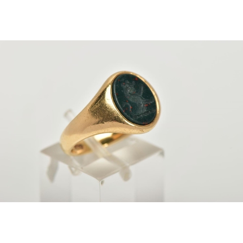 2 - AN EARLY 20TH CENTURY GOLD SIGNET RING, an oval bloodstone intaglio set into a yellow gold tapered b... 