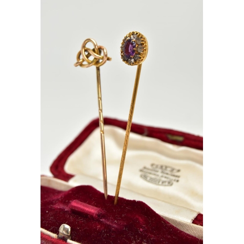 54 - TWO YELLOW METAL STICK PINS, the first detailed with an oval cluster, centring on an oval cut amethy... 