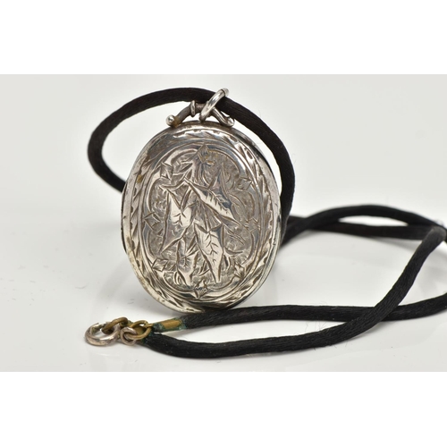 66 - A LATE 19TH CENTURY SILVER LOCKET, an oval locket detailing a foliage engraved pattern to the front,... 