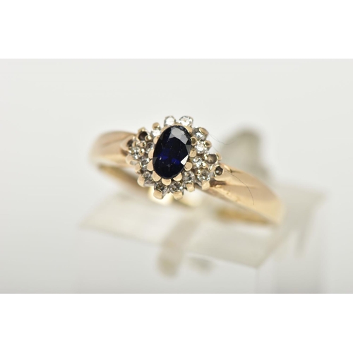 76 - A 9CT GOLD CLUSTER RING, a blue oval stone believed to be sapphire, set with a surround of round bri... 