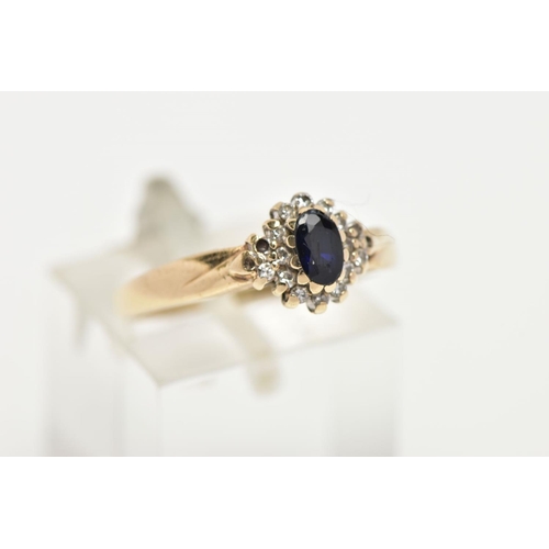 76 - A 9CT GOLD CLUSTER RING, a blue oval stone believed to be sapphire, set with a surround of round bri... 