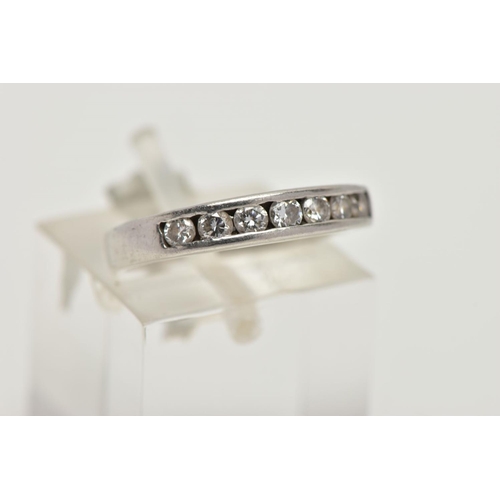 85 - A PLATINUM DIAMOND HALF ETERNITY RING, designed with a row of channel set round brilliant cut diamon... 